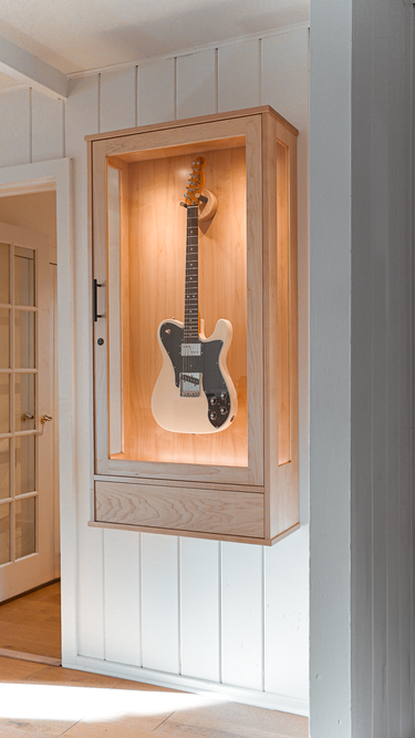 a fender 70s telecaster in a guitar display wall cabinet in maple