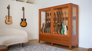 cherry guitar display case with climate controlled humidification in a music room with guitar wall hangers