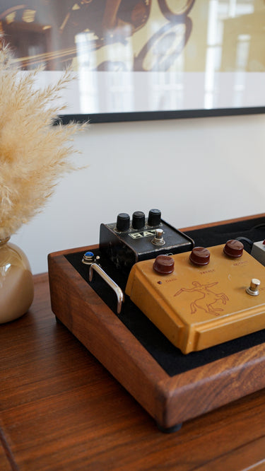vintage rat distortion pedal and original klon centaur overdrive pedal on a custom walnut pedalboard